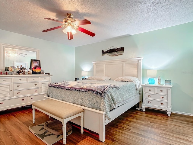 bedroom featuring wood-type flooring, a textured ceiling, and ceiling fan