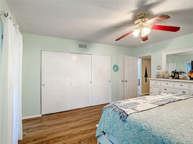 bedroom featuring a textured ceiling, ceiling fan, and hardwood / wood-style floors