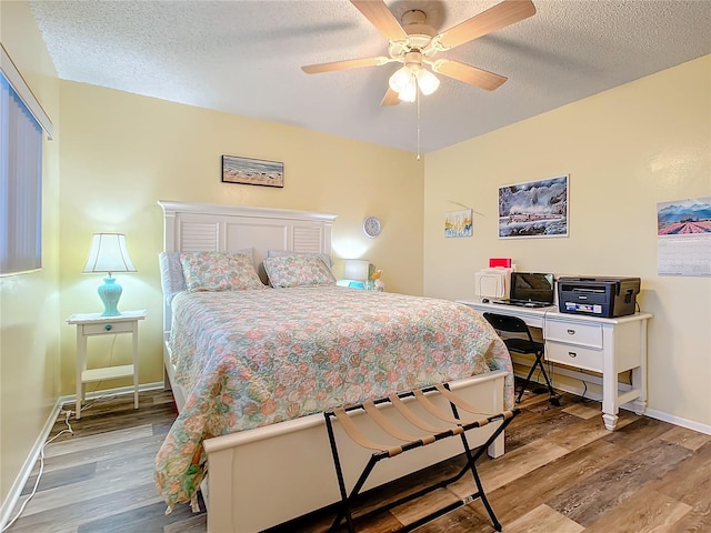 bedroom with light hardwood / wood-style floors, a textured ceiling, and ceiling fan