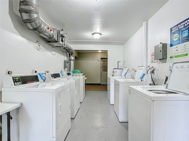 laundry area with washing machine and dryer and a textured ceiling