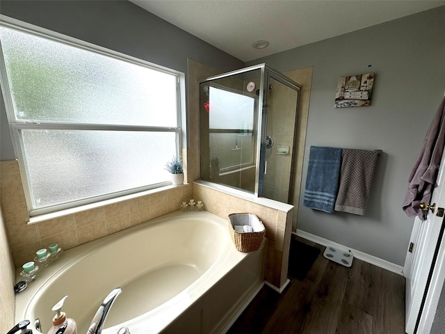 bathroom with hardwood / wood-style flooring and shower with separate bathtub