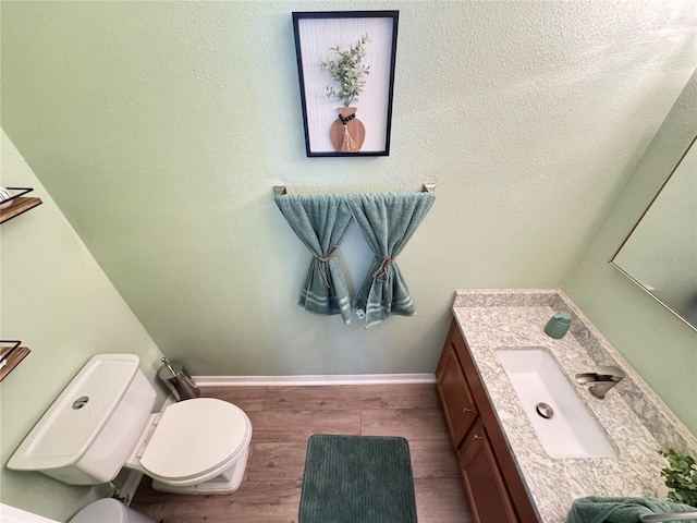 6546 Marlberry Way, Largo, FL 33773 - half bath with vanity, baseboards, wood finished floors, and toilet