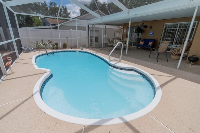 view of pool with a patio, ceiling fan, and a lanai