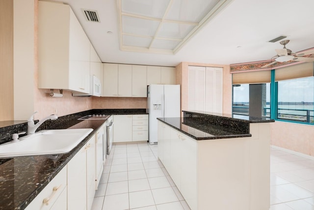 kitchen with a center island, light tile patterned flooring, a sink, white cabinets, and white appliances