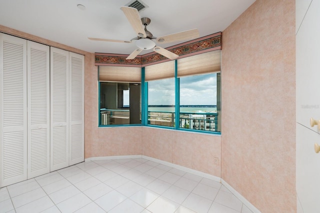 unfurnished bedroom featuring baseboards, visible vents, ceiling fan, tile patterned floors, and a closet