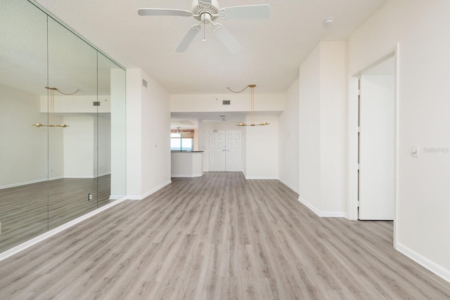 unfurnished living room featuring ceiling fan, baseboards, and wood finished floors