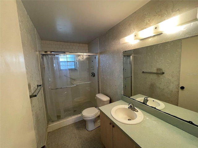 bathroom featuring tile patterned flooring, a shower with door, toilet, and vanity