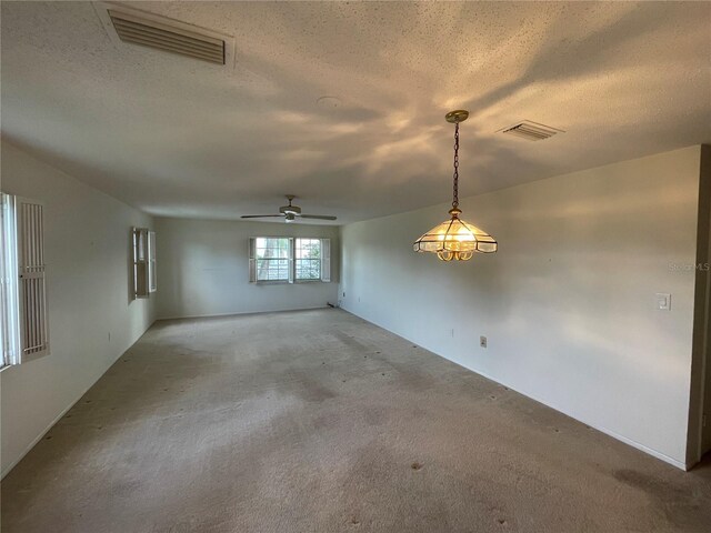 carpeted empty room featuring a textured ceiling and ceiling fan