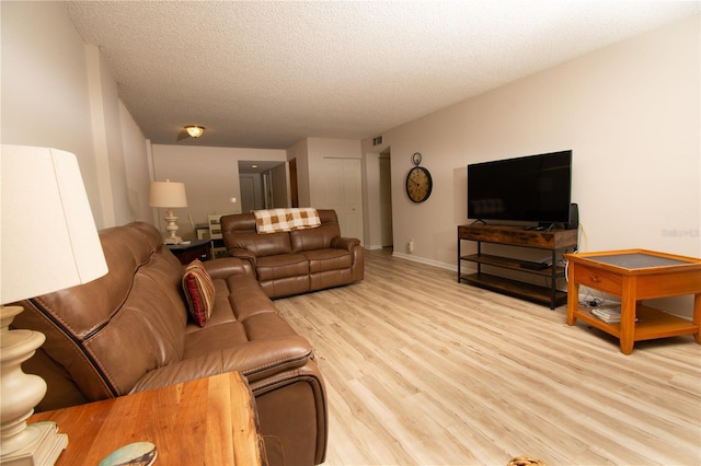 living room with light hardwood / wood-style floors and a textured ceiling