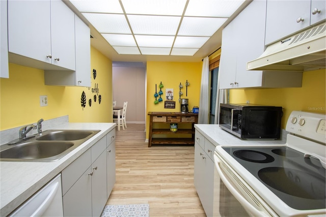 kitchen with light hardwood / wood-style flooring, white cabinets, premium range hood, stove, and sink