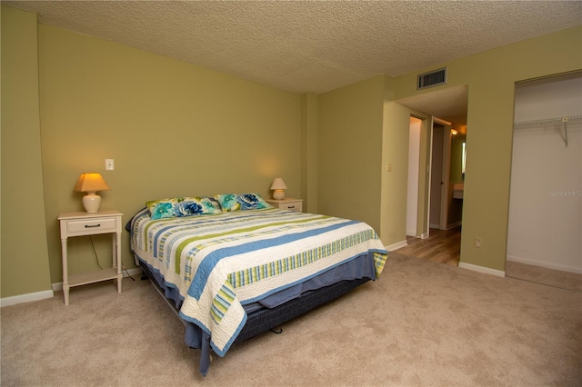 carpeted bedroom featuring a closet and a textured ceiling