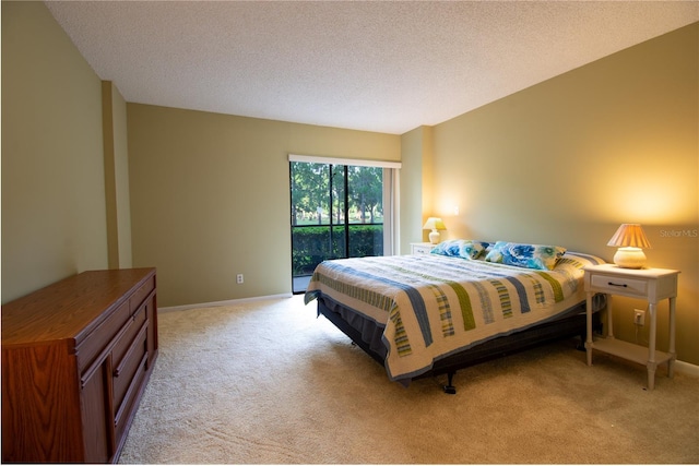 carpeted bedroom with access to exterior and a textured ceiling