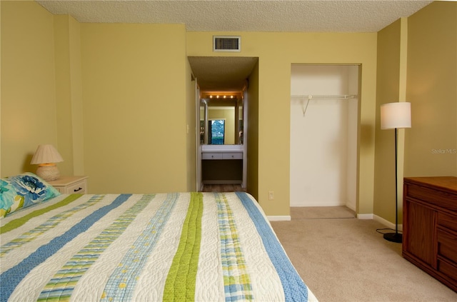 bedroom featuring light carpet, a closet, and a textured ceiling