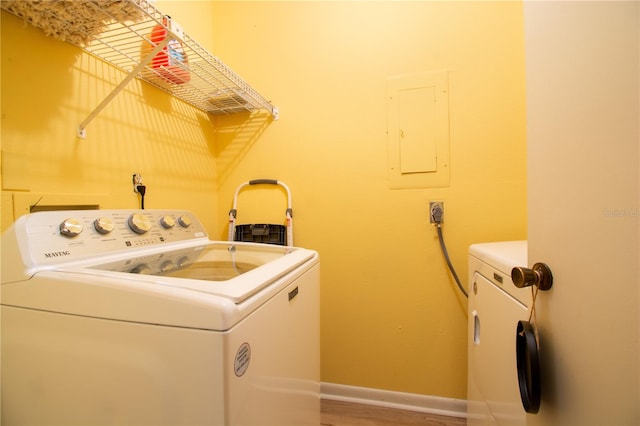 laundry area with hardwood / wood-style flooring, independent washer and dryer, and electric panel