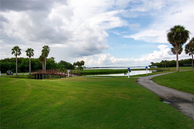 view of home's community with a water view and a lawn