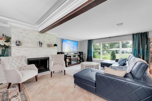 tiled living room with ornamental molding and a stone fireplace