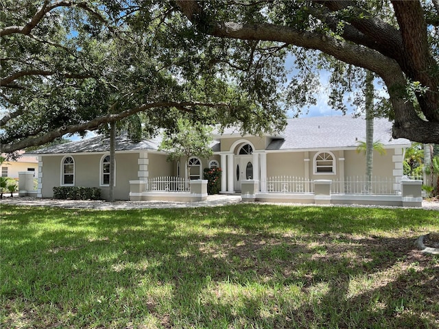 ranch-style home with a front yard and stucco siding