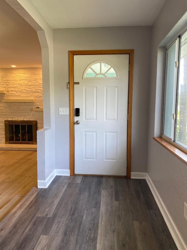 doorway featuring a fireplace and dark hardwood / wood-style flooring