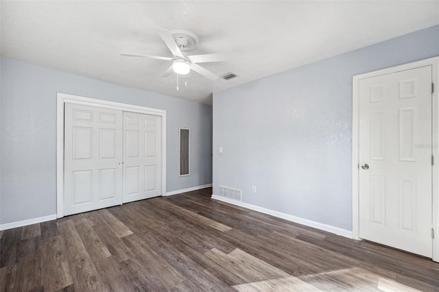 unfurnished bedroom featuring dark hardwood / wood-style flooring, a closet, and ceiling fan