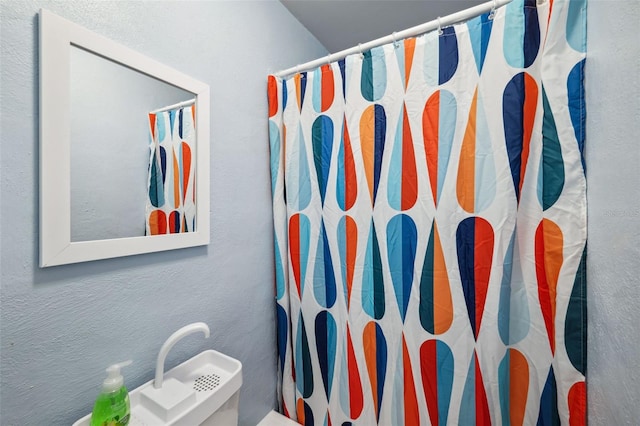 bathroom with curtained shower and toilet