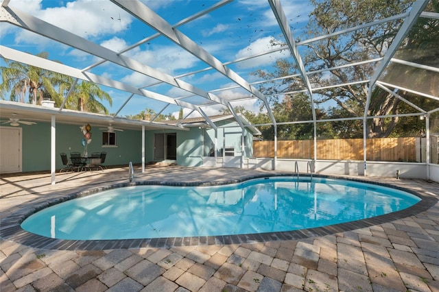 view of swimming pool featuring a lanai, a patio area, and ceiling fan