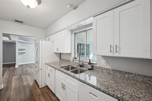 kitchen with sink, white cabinets, dark hardwood / wood-style flooring, light stone counters, and white appliances