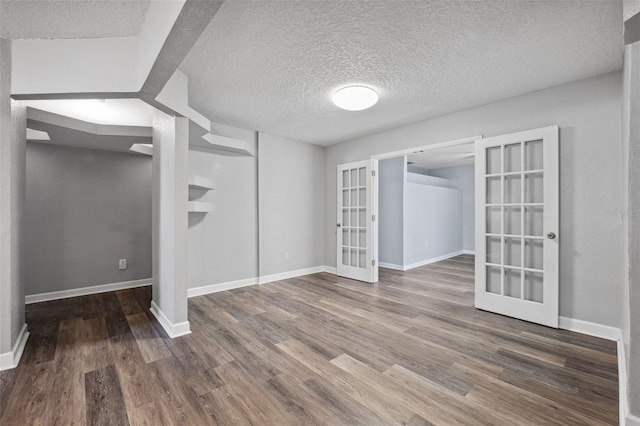 interior space featuring french doors, dark hardwood / wood-style floors, and a textured ceiling