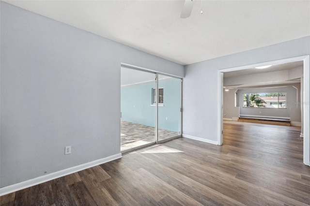 spare room with a baseboard heating unit, hardwood / wood-style flooring, and ceiling fan