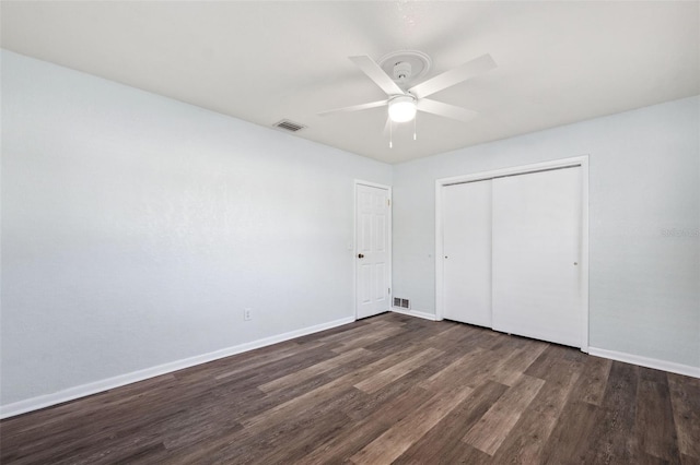 unfurnished bedroom with ceiling fan, dark hardwood / wood-style floors, and a closet