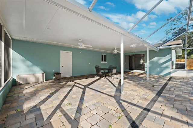 exterior space featuring ceiling fan and glass enclosure