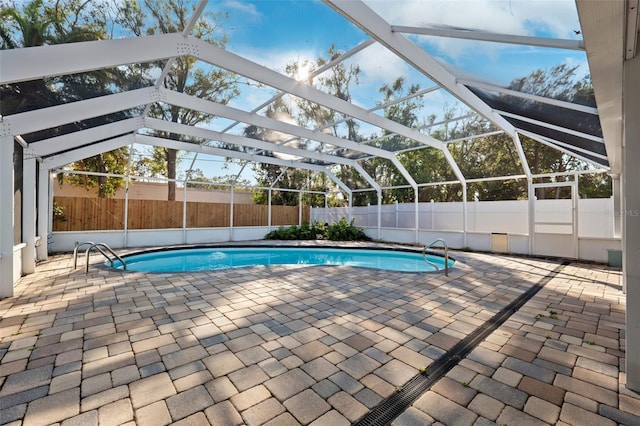 view of swimming pool with a patio area and glass enclosure