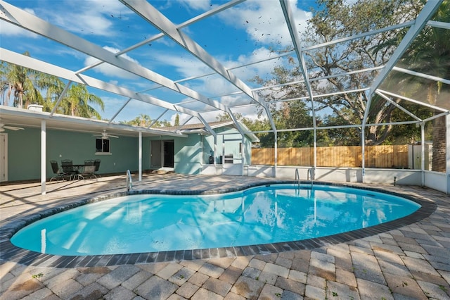 view of swimming pool with ceiling fan, a lanai, and a patio