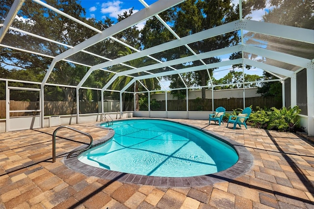 view of pool with a patio area and glass enclosure