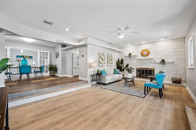 1549 Linwood Dr, Clearwater, FL 33755 - living area featuring a ceiling fan, baseboards, wood finished floors, a textured ceiling, and a fireplace