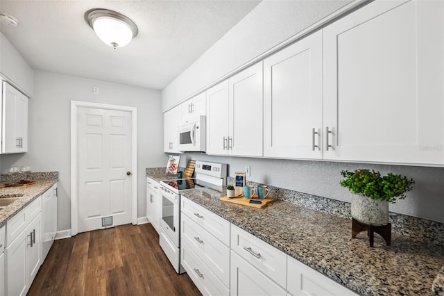 1549 Linwood Dr, Clearwater, FL 33755 - kitchen with white appliances, white cabinetry, dark wood-style flooring, stone countertops, and baseboards