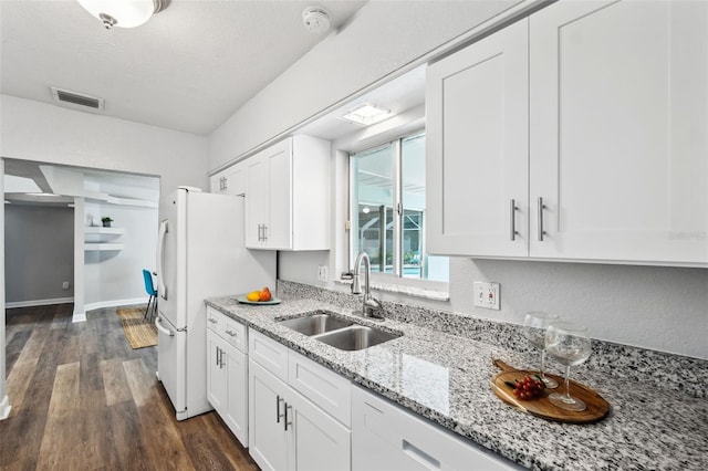 1549 Linwood Dr, Clearwater, FL 33755 - kitchen featuring a sink, dark wood-type flooring, white cabinets, freestanding refrigerator, and light stone counters
