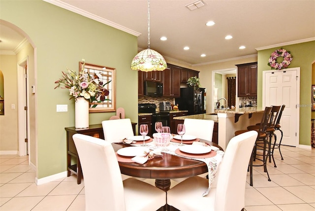 dining room with crown molding, sink, and light tile patterned floors