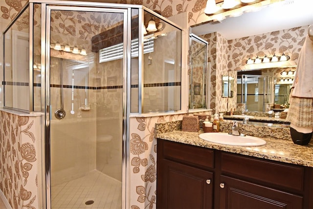 bathroom featuring an enclosed shower and vanity