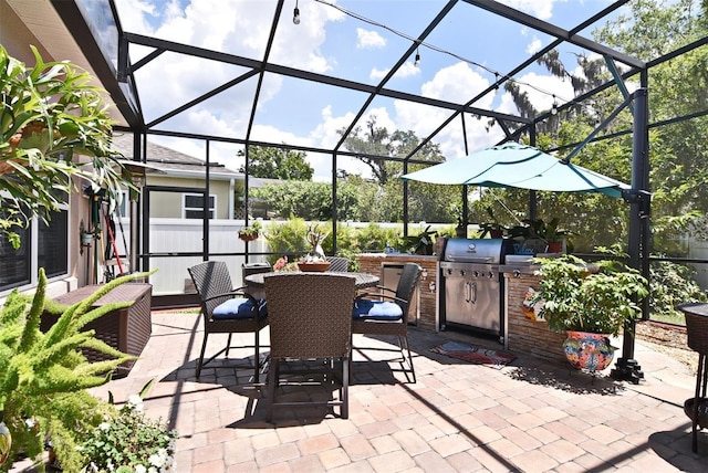 view of patio with area for grilling and a lanai