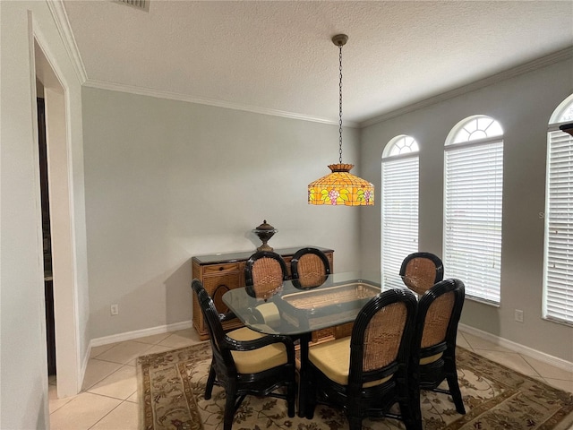 dining space featuring light tile patterned flooring, plenty of natural light, a textured ceiling, and crown molding