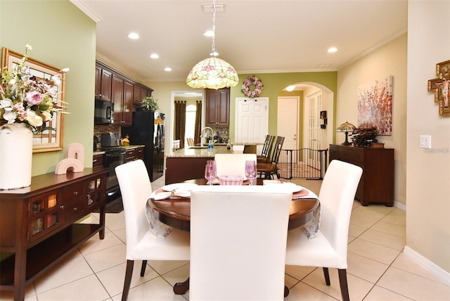 dining room featuring crown molding, sink, and light tile patterned floors