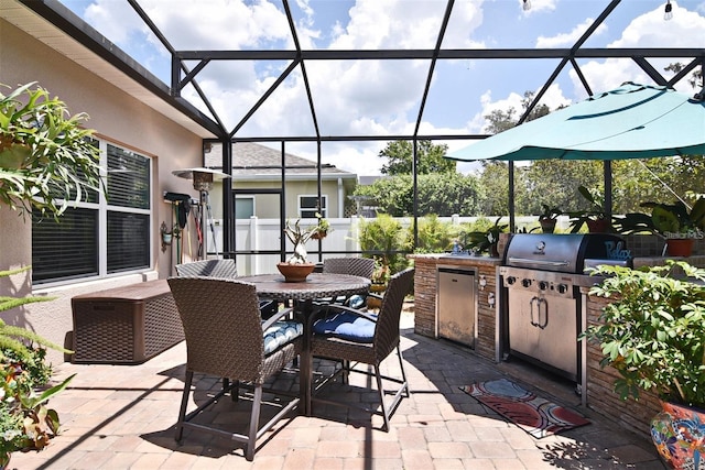 view of patio / terrace with grilling area, glass enclosure, and exterior kitchen