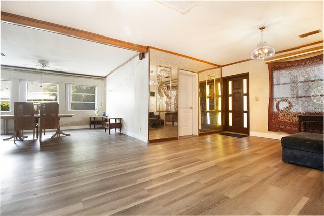 foyer entrance featuring baseboards, wood finished floors, and ceiling fan with notable chandelier