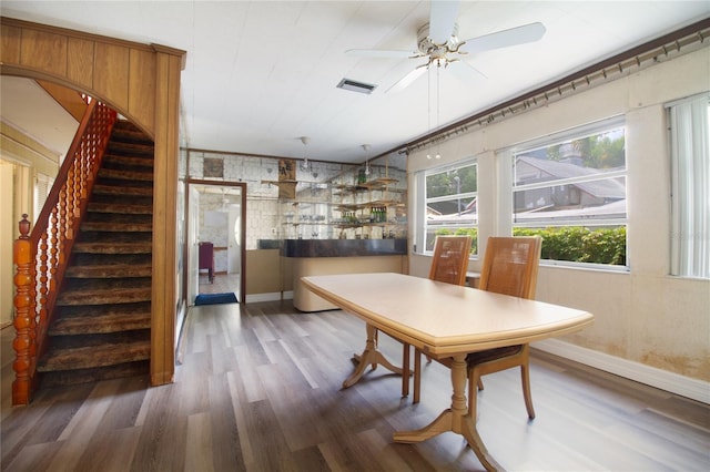 dining room featuring stairway, wood finished floors, visible vents, and baseboards