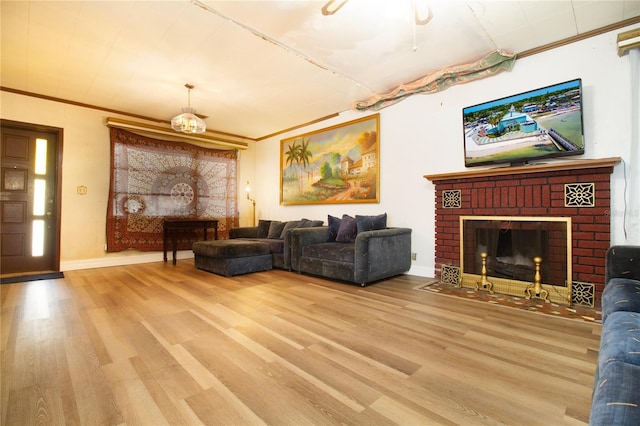 living room featuring a brick fireplace, baseboards, ornamental molding, and wood finished floors