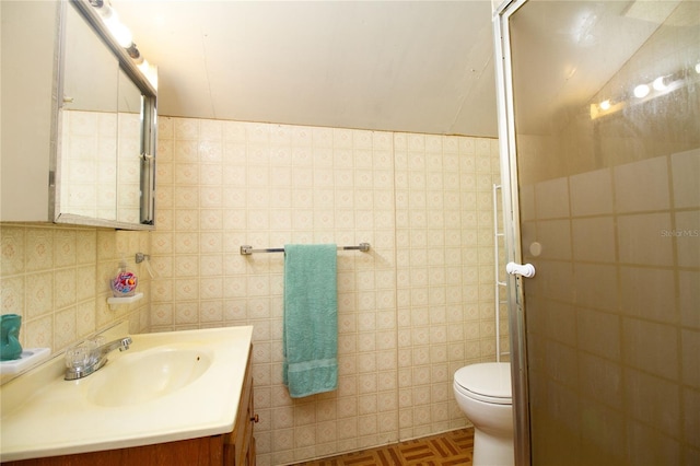 full bath with toilet, a stall shower, tile walls, and vanity