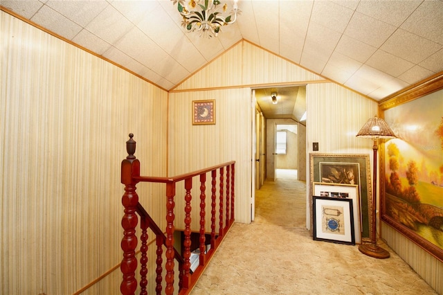 hall with ornamental molding, lofted ceiling, and carpet flooring