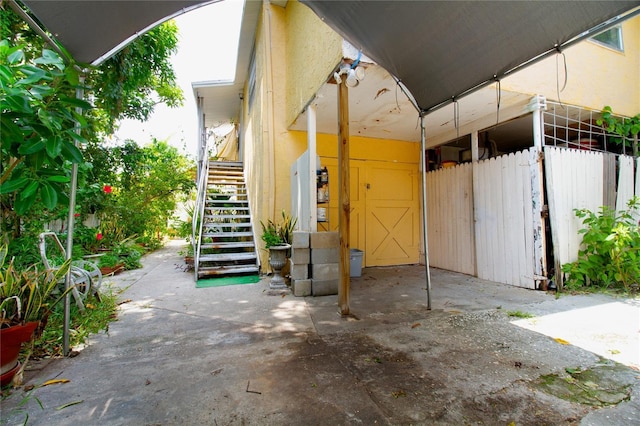 view of patio featuring stairs and fence