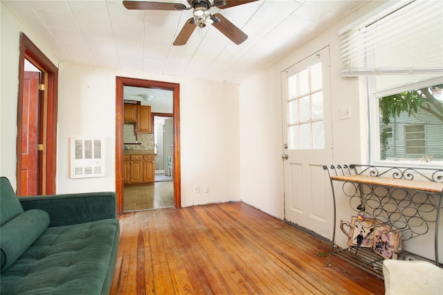 living room with a ceiling fan, visible vents, and hardwood / wood-style floors