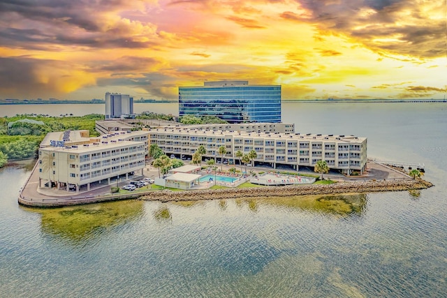 aerial view at dusk featuring a water view